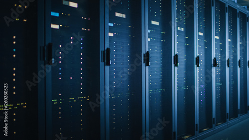 Shot of Dark Data Center With Multiple Rows of Fully Operational Server Racks. Modern Telecommunications, Cloud Computing, Artificial Intelligence, Database, Supercomputer. Blue Neon Light.