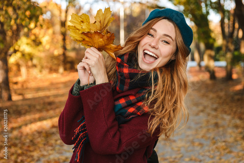 Cheerful young girl with long brown hair wearing autumn