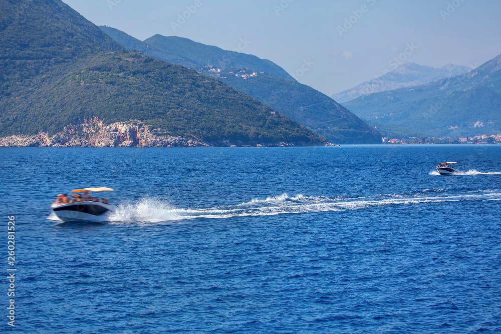 Fototapeta premium motorboats with tourists speeding on the bay