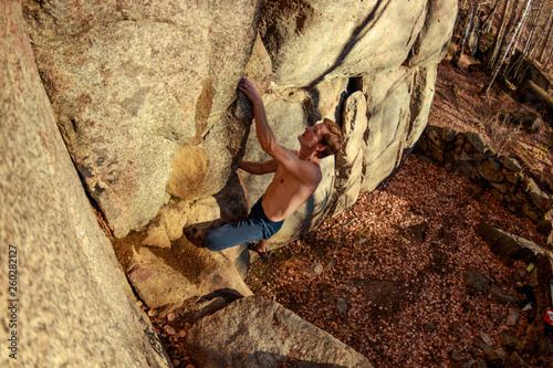 rock climber climbs a boulder over a rock without insurance