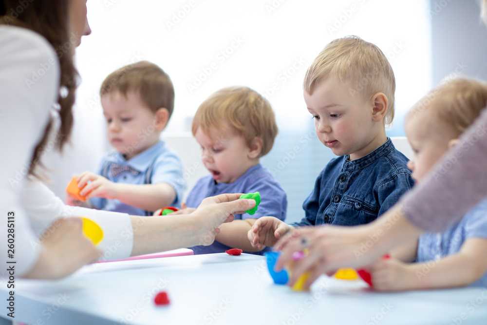 Children with teacher play colorful clay toy Children with teacher play colorful clay toy