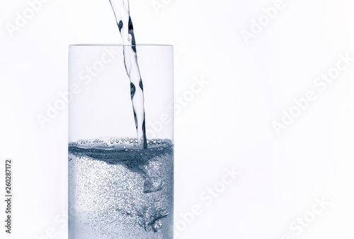 sparkling water with bubbles is poured into glass
