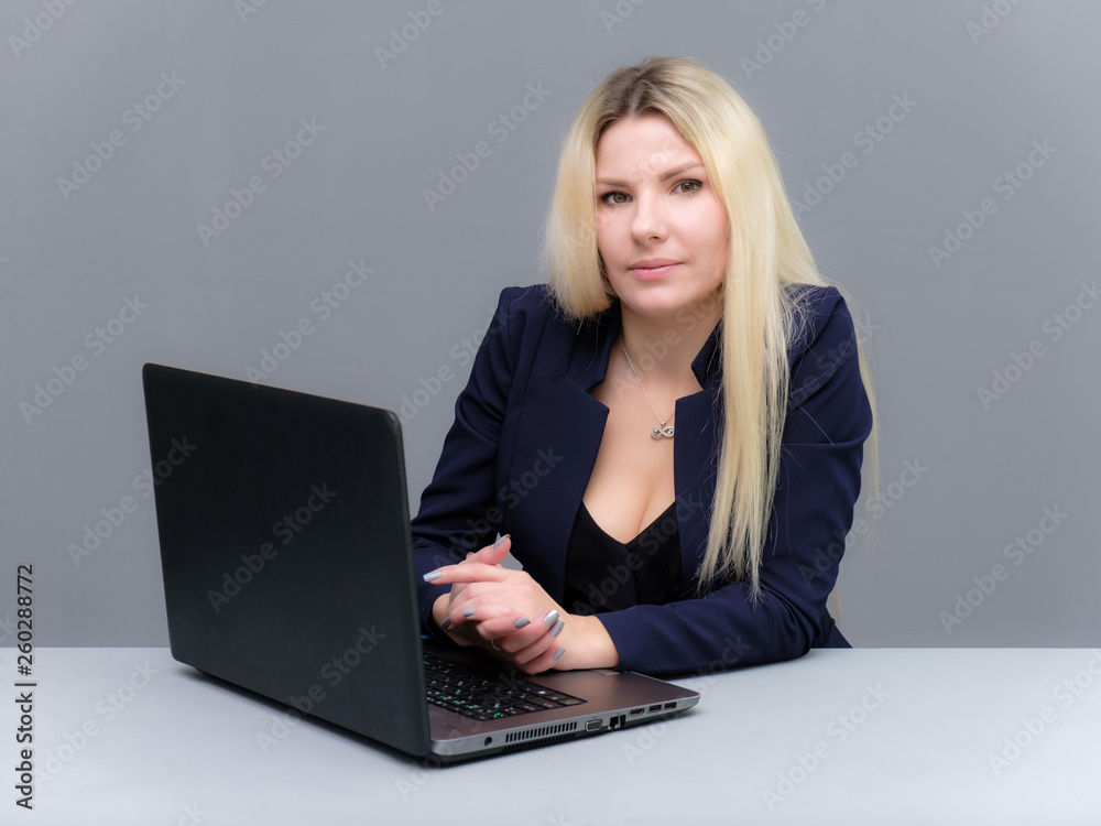 Portrait of happy smiling young cheerful businesswoman sitting with a laptop. Success in business concept studio shot talking to a client. Portrait of happy smiling young cheerful businesswoman sitting with a laptop. Success in business concept studio shot talking to a client.