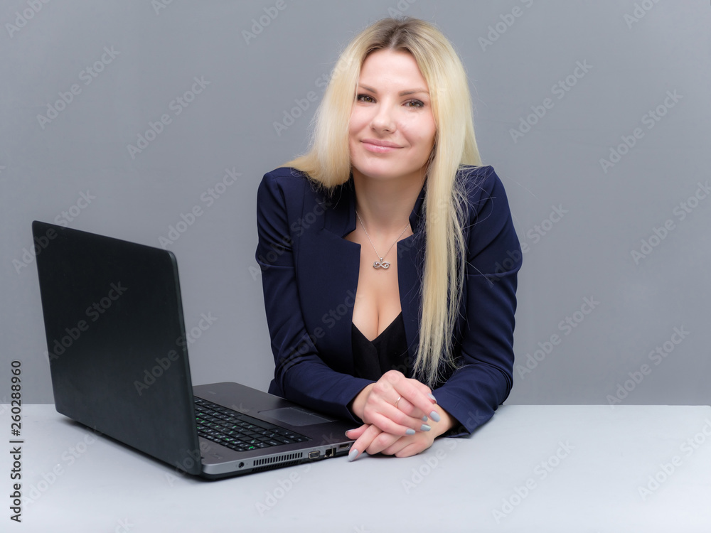 Portrait of happy smiling young cheerful businesswoman sitting with a laptop. Success in business concept studio shot talking to a client. Portrait of happy smiling young cheerful businesswoman sitting with a laptop. Success in business concept studio shot talking to a client.