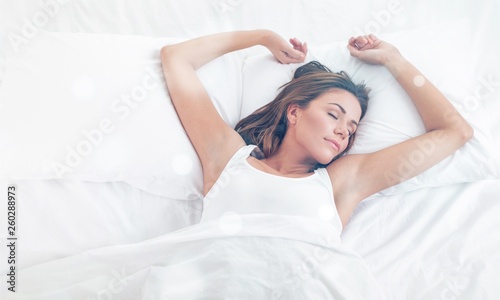 Young woman sleeping on the white linen in bed at home