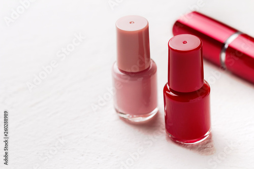 Nail polish and lipstick on a white background.