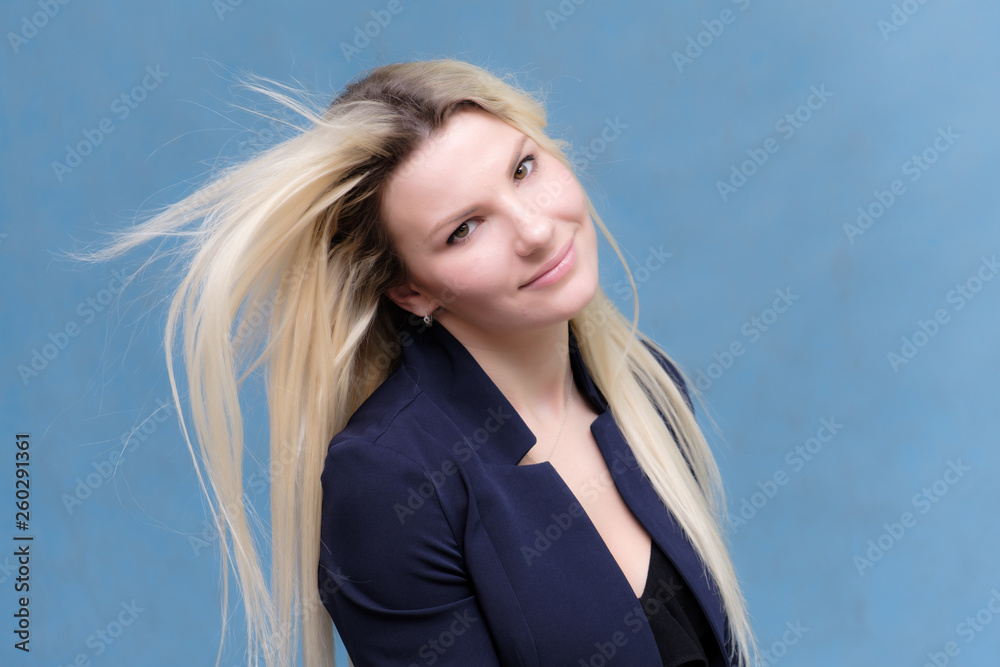 Portrait of happy smiling young cheerful businesswoman standing with flowing hair. Success in business concept studio shot. Blue suit. Portrait of happy smiling young cheerful businesswoman standing with flowing hair. Success in business concept studio shot. Blue suit.