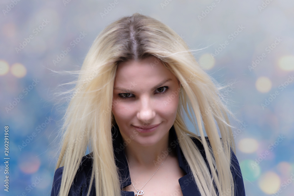 Naklejka premium Portret szczęśliwy uśmiechnięty młody wesoły bizneswoman stojący z włosami. Sukces w strzał studyjny koncepcji biznesowej. Niebieski garnitur. Wielokolorowe tło ściany.