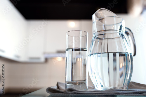 A glass of fresh water with crafin on the background of a modern kitchen.