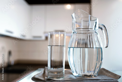 A glass of fresh water with crafin on the background of a modern kitchen.