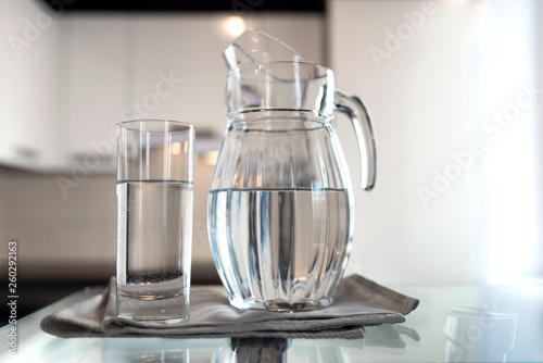 A glass of fresh water with crafin on the background of a modern kitchen.