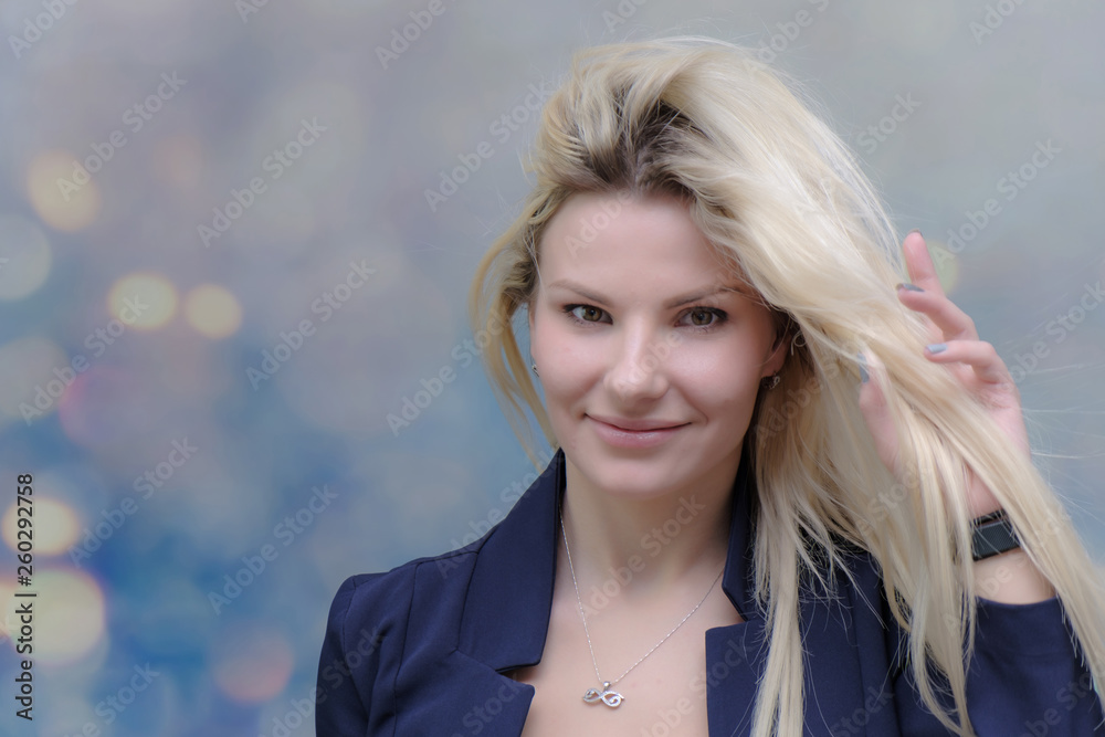 Obraz premium Portrait of happy smiling young cheerful businesswoman standing with flowing hair. Success in business concept studio shot. Blue suit. Multicolor wall background.