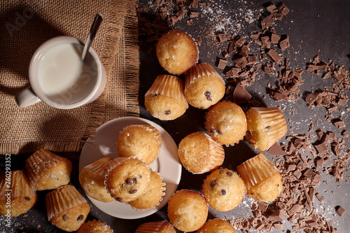 group of muffins next to a cup of milk