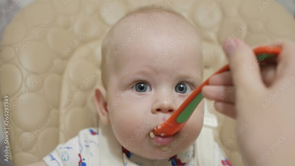 A six-month-old baby boy first tries baby food. Healthy nutrition for children. A six-month-old baby boy first tries baby food. Healthy nutrition for children.