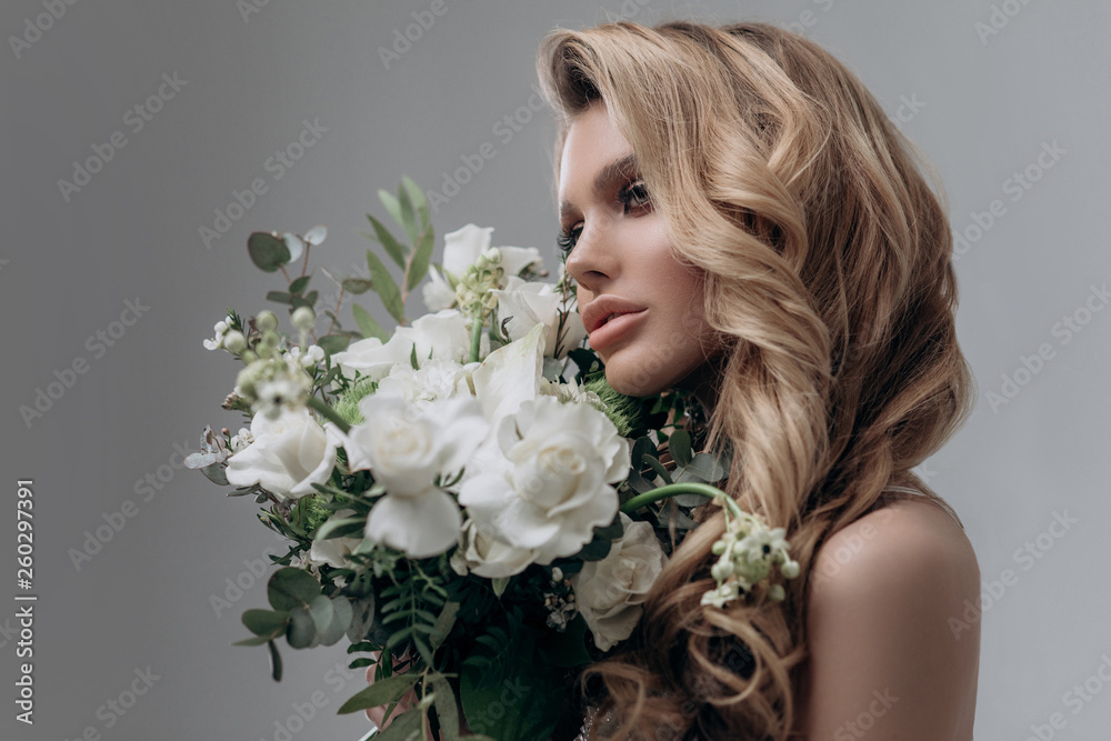 beautiful sexy blonde bride posing in a sparkling wedding dress with bouquet. advertising space