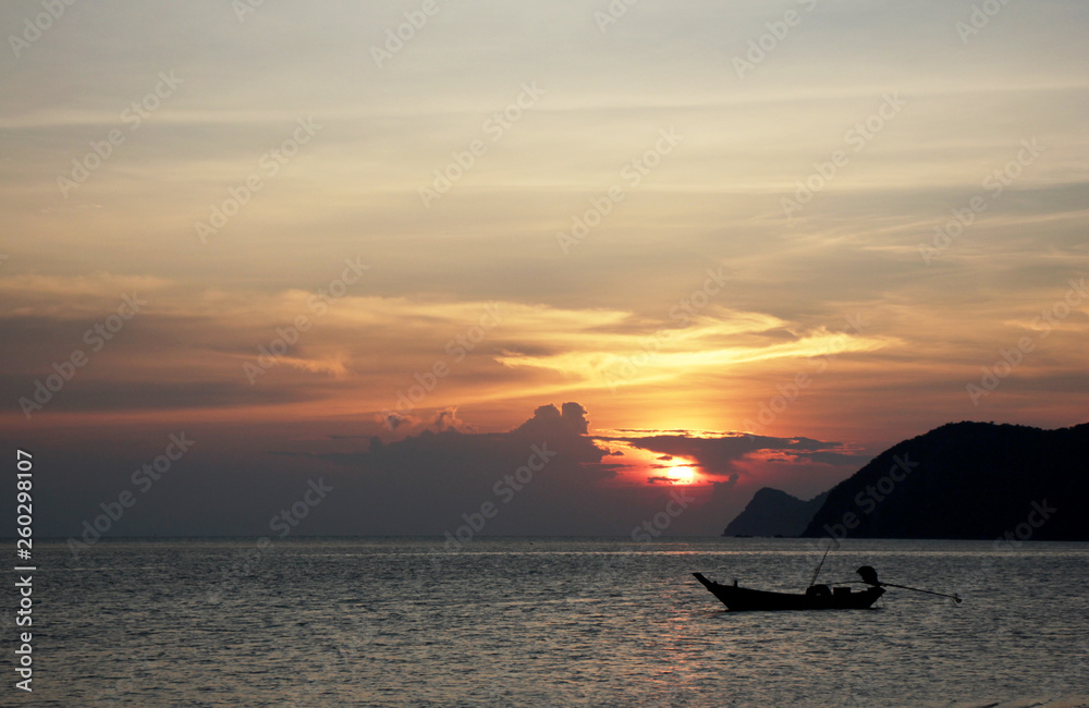 Sunset in Thailand with traditional boat at background