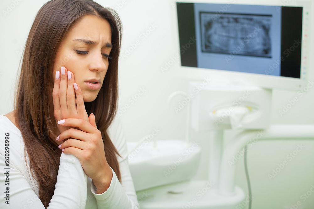 Young female having toothache. Upset woman at the dentist. Constant pulsating pain Young female having toothache. Upset woman at the dentist. Constant pulsating pain