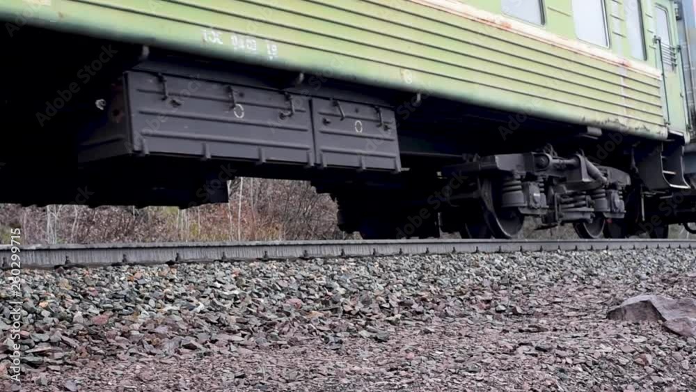 Electric train with old passenger cars covered with old paint and rust goes by rail on the rails in early spring Electric train with old passenger cars covered with old paint and rust goes by rail on the rails in early spring