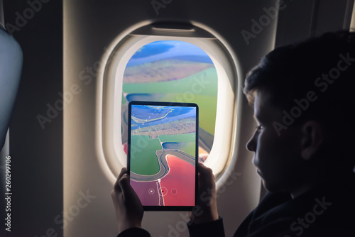 Caucasian boy using tablet pc for taking picture through plane window Salt Ponds in Don Edwards. San Francisco Bay National Wildlife Refuge. California. USA photo