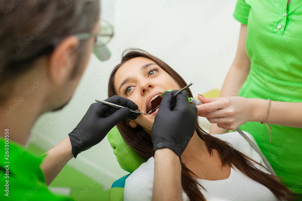The dentist man are treating teeth to client in dental office The dentist man are treating teeth to client in dental office