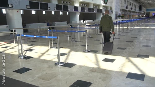 Young Man Luggage Suitcase Walking In Airport Terminal photo