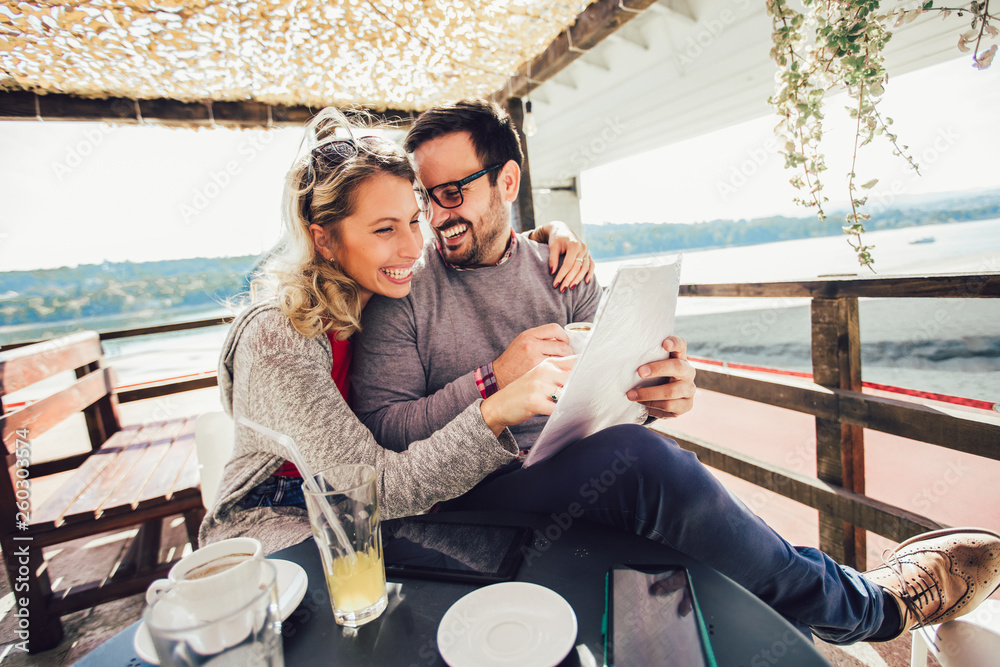 Young cheerful man and woman dating and spending time together in cafe