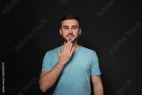 Man showing THANK YOU gesture in sign language on black background