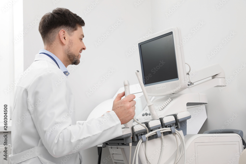 Sonographer operating modern ultrasound machine in clinic Sonographer operating modern ultrasound machine in clinic