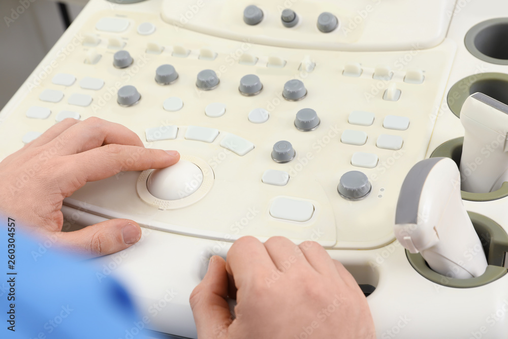 Sonographer operating modern ultrasound machine in clinic, closeup Sonographer operating modern ultrasound machine in clinic, closeup