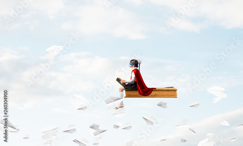 Girl power concept with cute kid guardian against cloudscape background