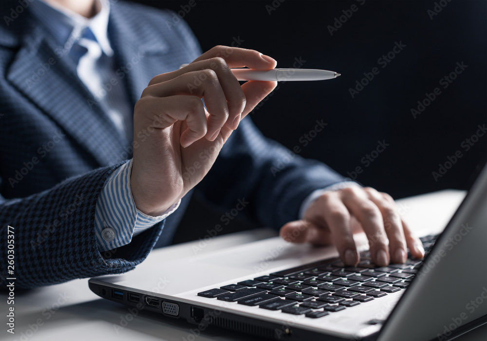 Man in business suit sitting at desk with laptop