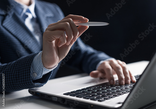 Man in business suit sitting at desk with laptop photo