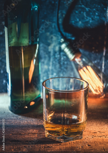 A glass of whisky on rough wooden background