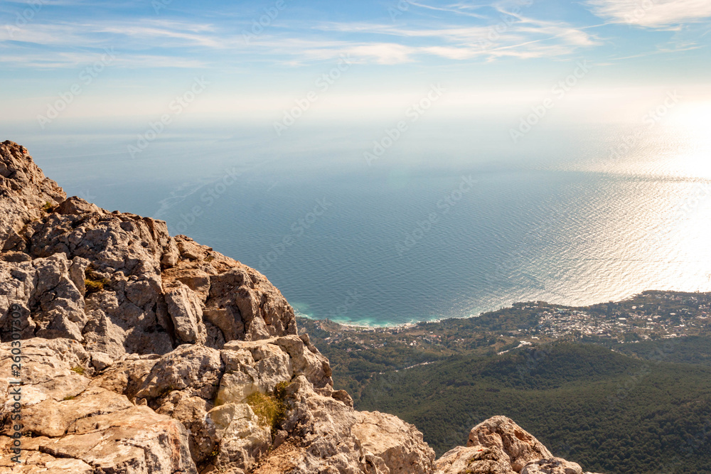 View from the top of AI-Petri mountain in Crimea, Russia. High rocks of Crimean mountains, black sea coast and blue sky with clouds.