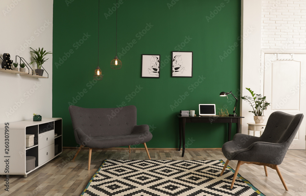 Modern living room interior with workplace near green wall - obrazy, fototapety, plakaty 