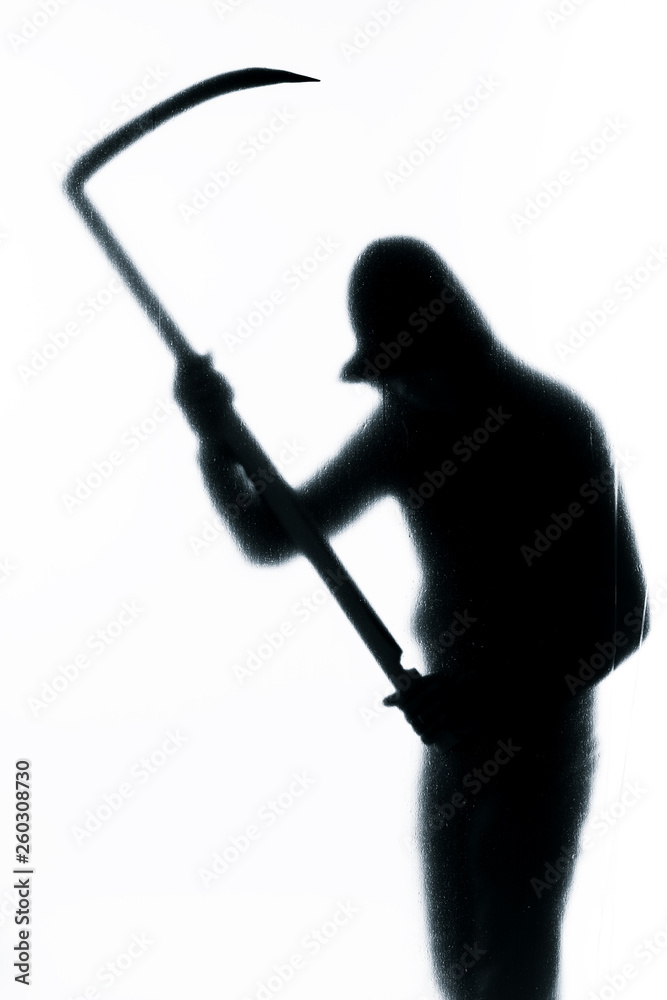 Dangerous man behind frosted glass with a scythe in his hand. Halloween. Black and white image.