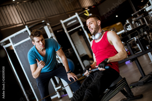 Young man with trainer doin...