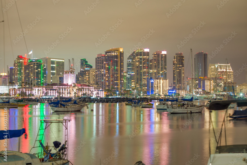 Obraz premium SAN DIEGO, CA - JULY 31, 2017: Night reflections of Downtown San Diego from the city port. The city attracts 10 million tourists annually