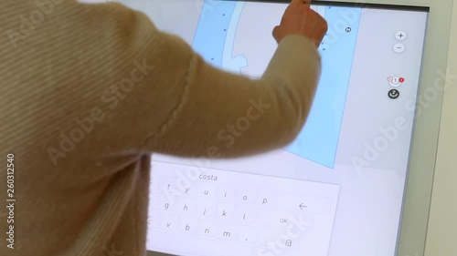 The woman uses an interactive panel as a shopping center guide. Paves the way to the desired store