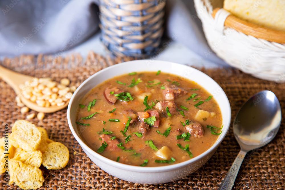 Peas soup with meat, smoked sausage and croutons. Selective focus, close-up. Peas soup with meat, smoked sausage and croutons. Selective focus, close-up.