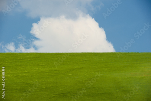 tipico paesaggio italiano, raffigurante distese verdi e cieli azzurri movimentati da nuvole bianche photo