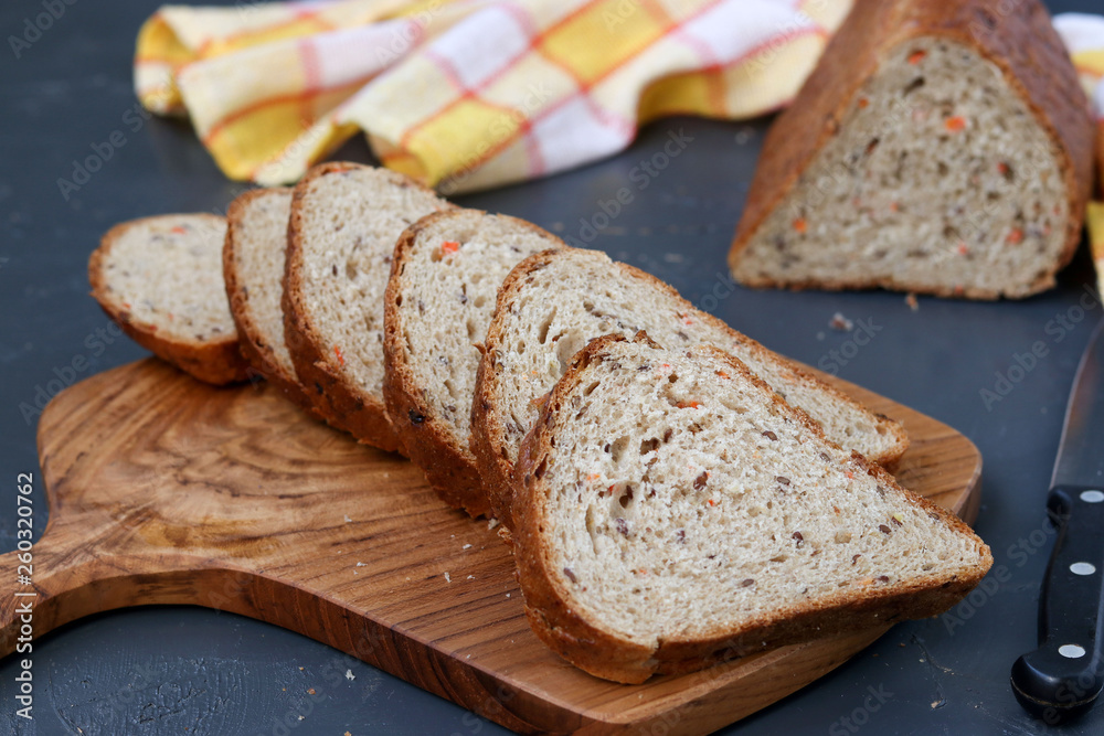 Whole grain carrot bread with flax seeds, located on a wooden board