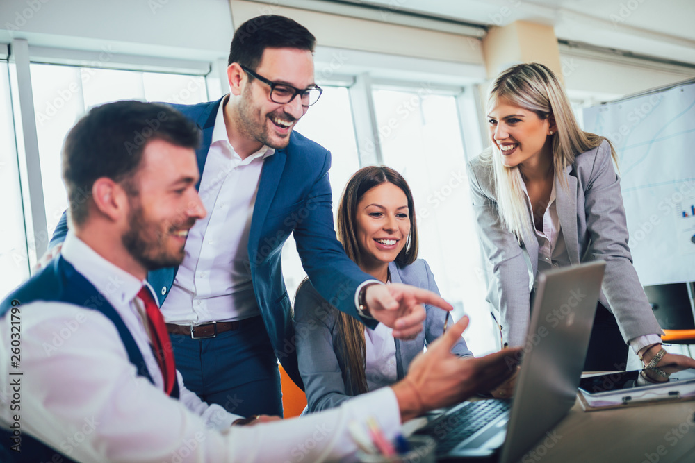 Group of young business people working and using laptop while sitting at the office desk together. Selective focus. Group of young business people working and using laptop while sitting at the office desk together. Selective focus.