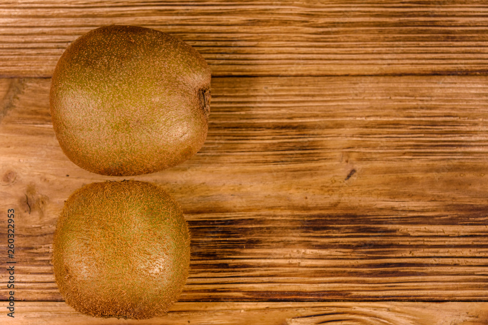 Two kiwi fruits on a wooden table. Top view Two kiwi fruits on a wooden table. Top view