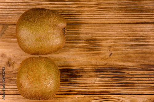 Two kiwi fruits on a wooden table. Top view