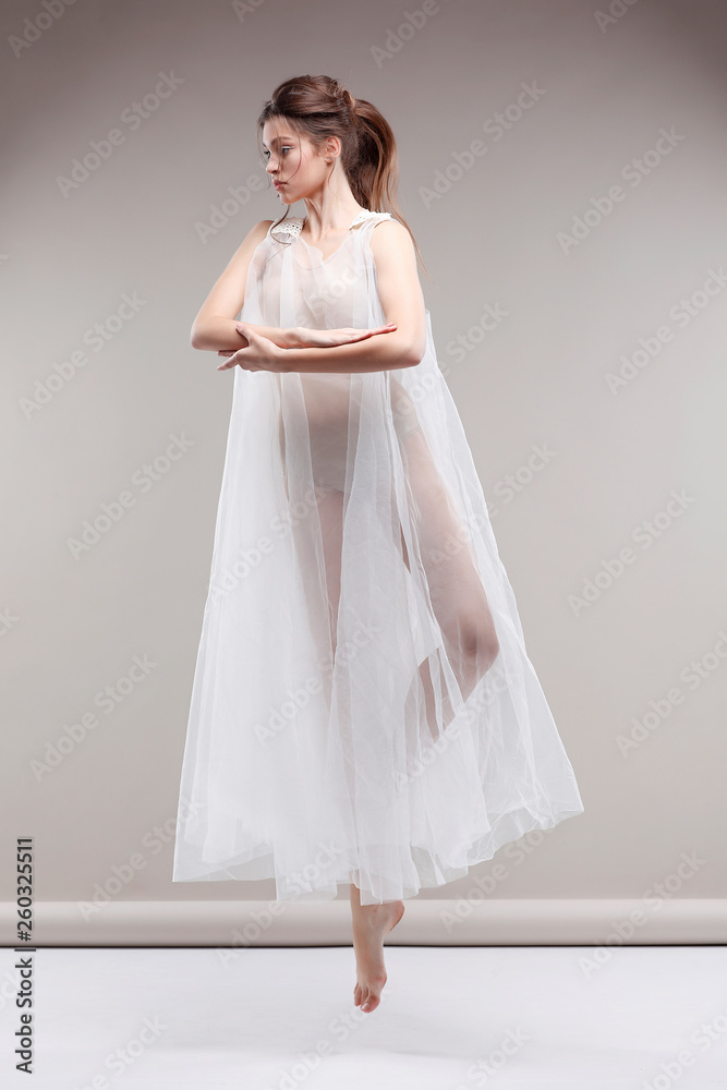 Fototapeta premium Beautiful ballet-dancer, modern style dancer posing on studio background