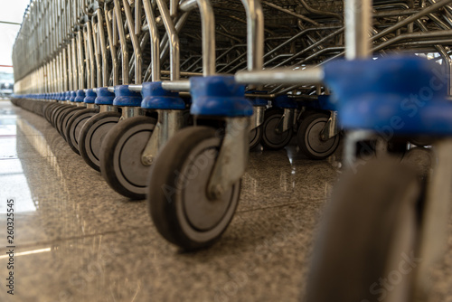Detail of lot of supermarket carts wheels with blue plastic