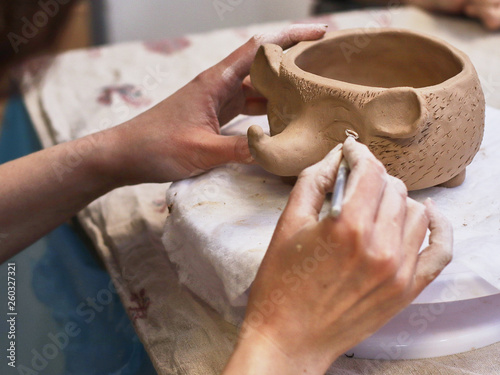 Hands in clay make a ceramic bowl photo