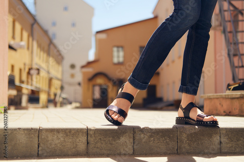 Female legs in sandals descending the stairs in the city photo
