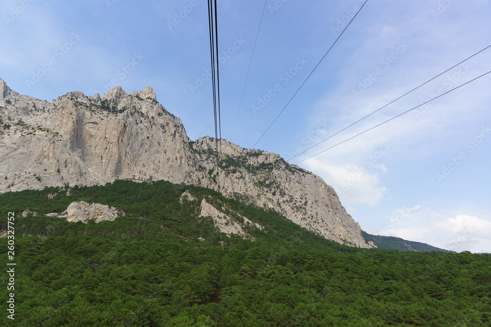 Ropes of suspended transport rise to the top of the high Crimean mountain AI-Petri